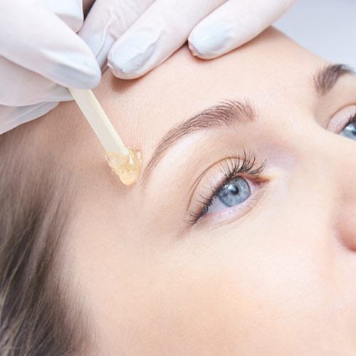 woman gettign eyebrow waxed at queen b spa